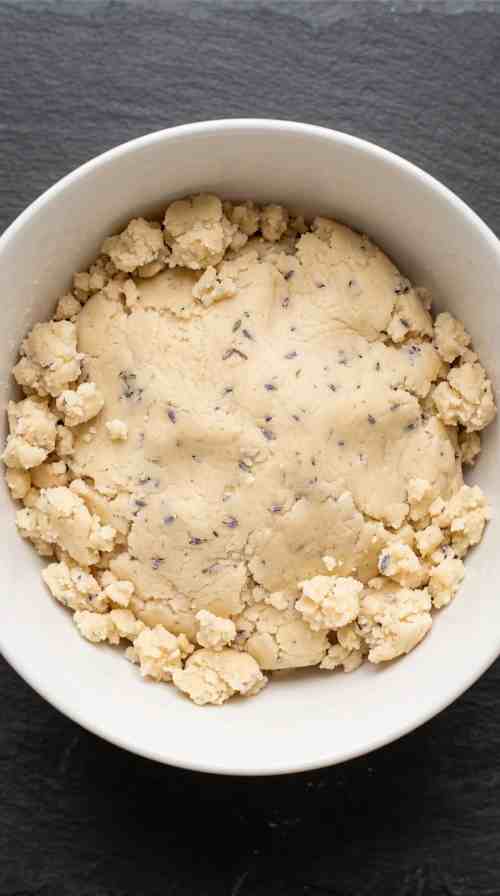 lavender-shortbread-cookies-process-step-3-adding-flour-to-shortbread-dough-in-bowl