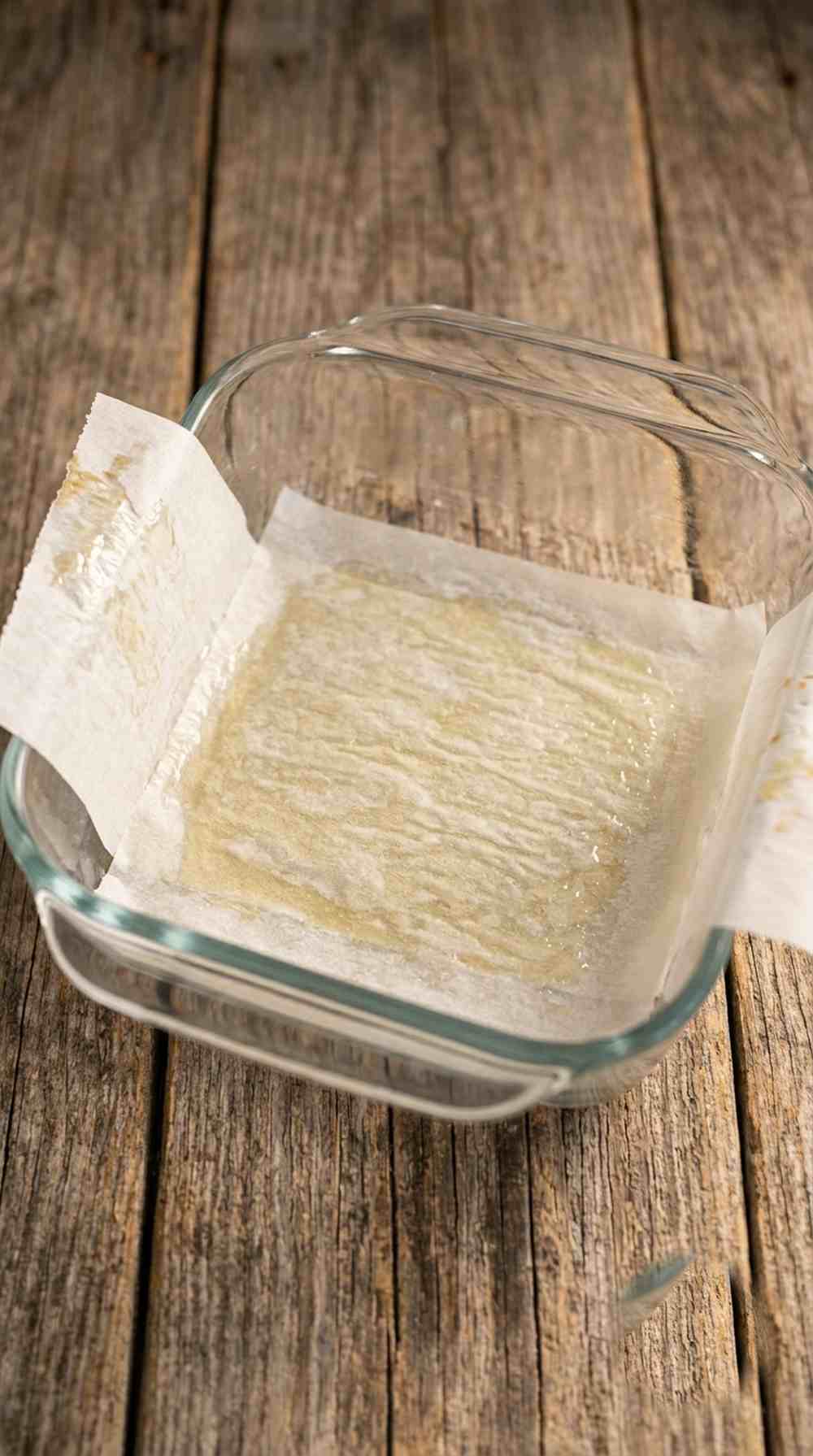 Parchment-lined baking dish ready for the graham cracker crust