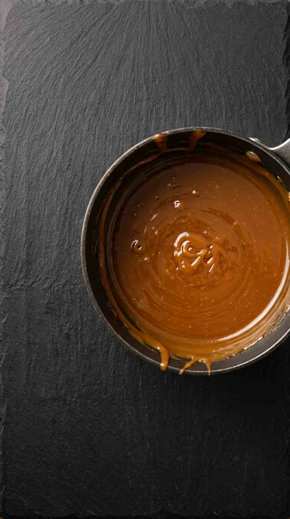 Pecan caramel sauce simmering in a saucepan until glossy