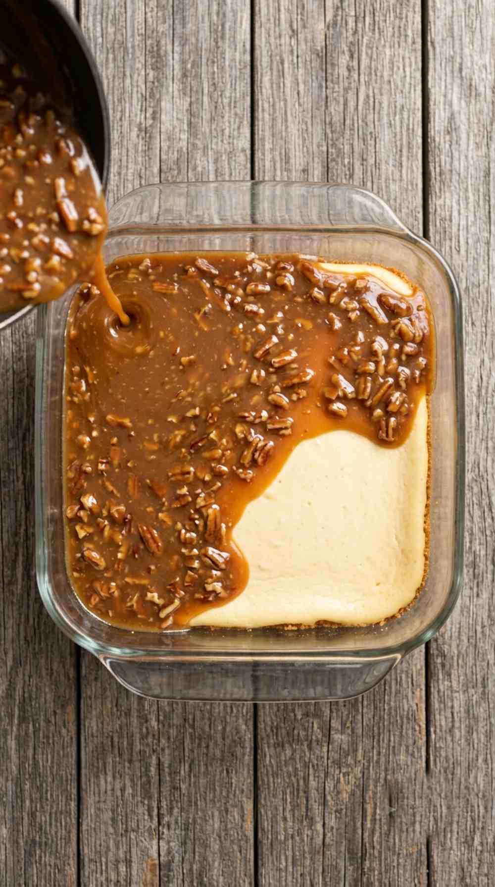Pouring the pecan caramel topping over the baked cheesecake layer